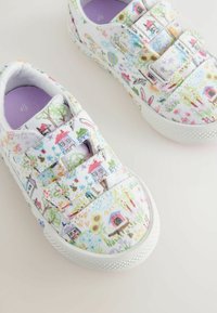 Baskets blanches en tissu avec des motifs floraux et de maison colorés dessinés à la main. Équipées de doubles bandes velcro et de semelles en caoutchouc texturé.