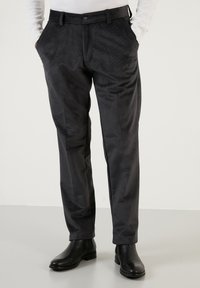 Fekete kordbársony nadrág, slim fit fazonnal, oldalzsebekkel és gombos zárással, sima textúrával és finom függőleges bordázattal.