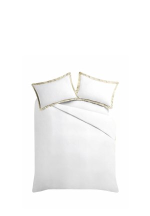 Lit blanc avec deux oreillers et une couette, chaque oreiller et couette bordés d'un liseré beige.