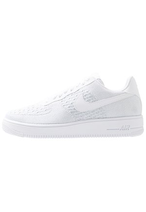 Hele witte gebreide lage sneaker met een witte zool, veters en een zichtbaar Nike swoosh-logo aan de zijkant.