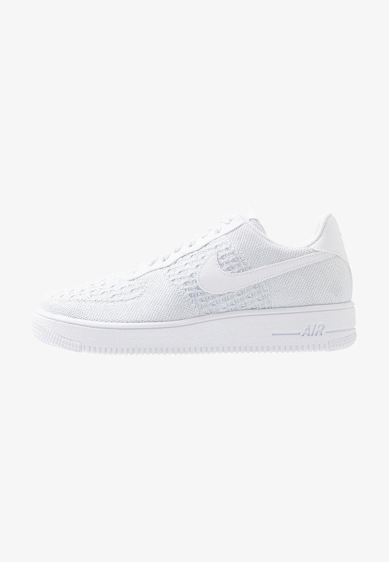 Baskets basses tricotées tout en blanc avec une semelle blanche, des lacets et un logo Nike swoosh visible sur le côté.