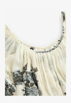 Blomstret bluse i lys cream med grå blomster. Let og gennemsigtig stof med sammensnoet tekstur og en rund halsudskæring.