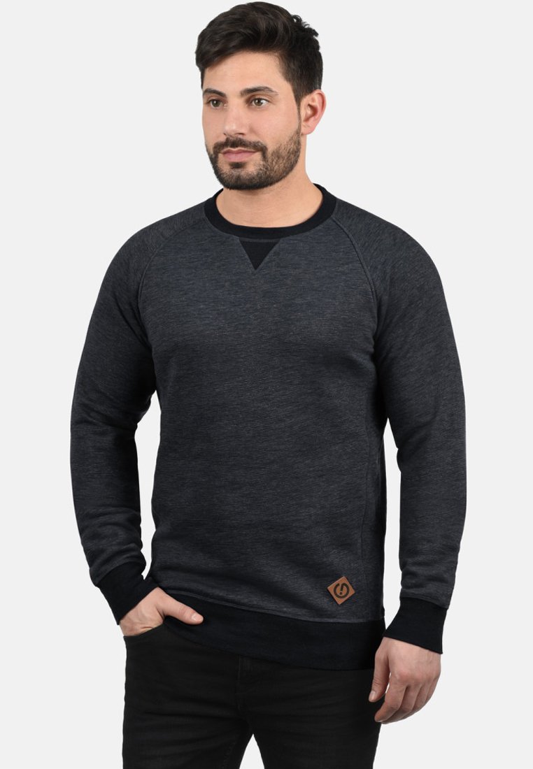 Donkergrijze sweatshirt met een ronde hals, raglanmouwen en een driehoekige accent aan de borst. Bevat een leren merklabel aan de zoom.