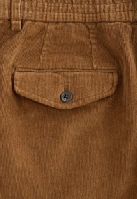 Brown corduroy pants featuring a textured finish, an elastic waistband, and a buttoned back pocket with a contrasting button detail.