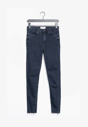 Mørkeblå skinny jeans med en frynset kant, lavet af denimstof. Har fem lommer og en knaplukning i taljen.