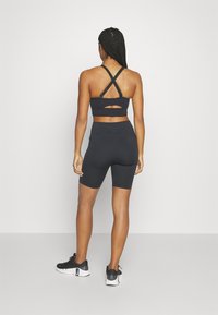 Under Armour SMARTFORM EVO MID - Sportovní podprsenky se střední oporou - black/white