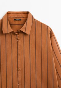 Brown button-up shirt with black vertical stripes and a pointed collar, shown flat against a white background.