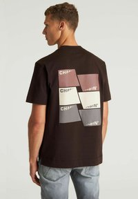 Zwarte katoenen t-shirt met een kleurrafgrafiek op de achterkant met rechthoekige stukken in beige, roze, grijs en wit.