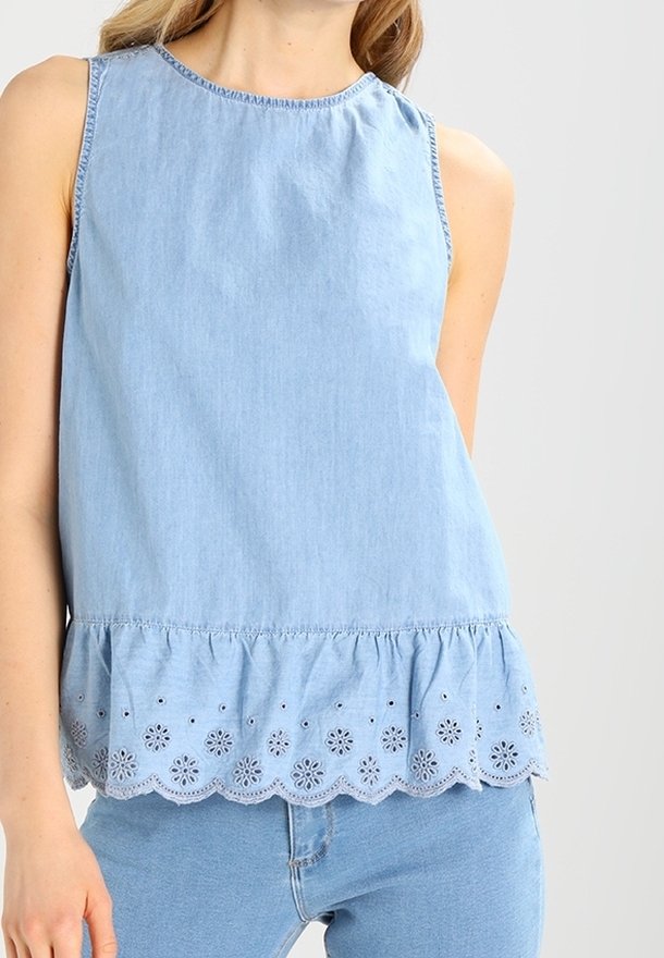 Haut sans manches bleu clair en coton, présentant un ourlet à volants avec des détails en dentelle florale. Texture douce et encolure ronde.