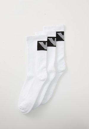 Chaussettes blanches en coton, pack de trois, présentant des motifs géométriques noirs sur le haut, avec une texture côtelée et un design de orteil renforcé.
