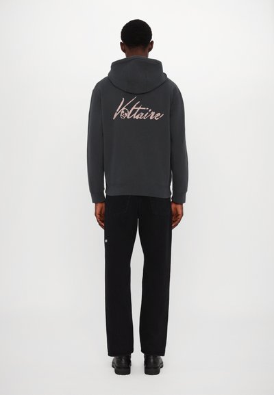 Dark gray hooded sweatshirt featuring a prominent pink logo on the back, paired with black pants and black shoes. Simple, casual design.