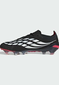 Μαύρο και άσπρο ποδοσφαιρικό παπούτσι με υφασμένο επάνω μέρος, λιτό σχεδιασμό και διάφανο πάτο. Κόκκινα στοιχεία στη φτέρνα και στα καρφιά.