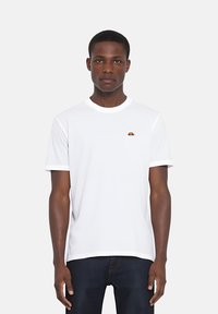 Maglietta bianca a maniche corte con scollo rotondo e un piccolo logo multicolore sul petto. Tessuto morbido e vestibilità comoda.