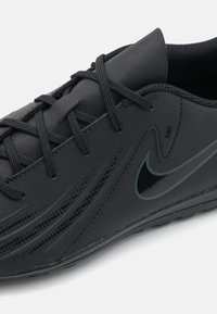 Juodas sportinis batelis su lygaus sintetinio paviršiaus, plokščiomis raištelėmis, subtilia tinklo tekstūra ir tamsiai Nike swoosh akcentu šone.