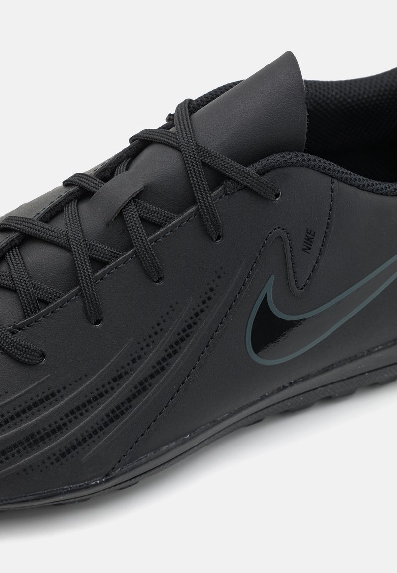 Schwarzer Sportschuhe mit einer glatten synthetischen Oberseite, flachen Schnürsenkeln, subtiler Mesh-Struktur und einem dunklen Nike-Swoosh-Akzent an der Seite.