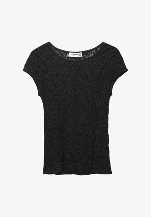 Musta lyhythihainen pitsipaita, jossa on kukkakuosi ja pyöreä pääntie, aseteltuna tasaisesti valkoista taustaa vasten.