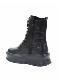 Czarne botki do kostki, wykonane ze skóry, z grubą platformą, sznurowanym przodem i zamkiem po boku dla łatwego zakładania. Gładka powierzchnia na całej długości.