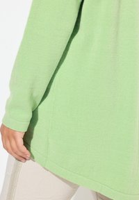 Maglione a maglia testurizzata verde chiaro, con maniche lunghe, orlo arrotondato e polsini a costine. Materiale morbido, vestibilità casual.