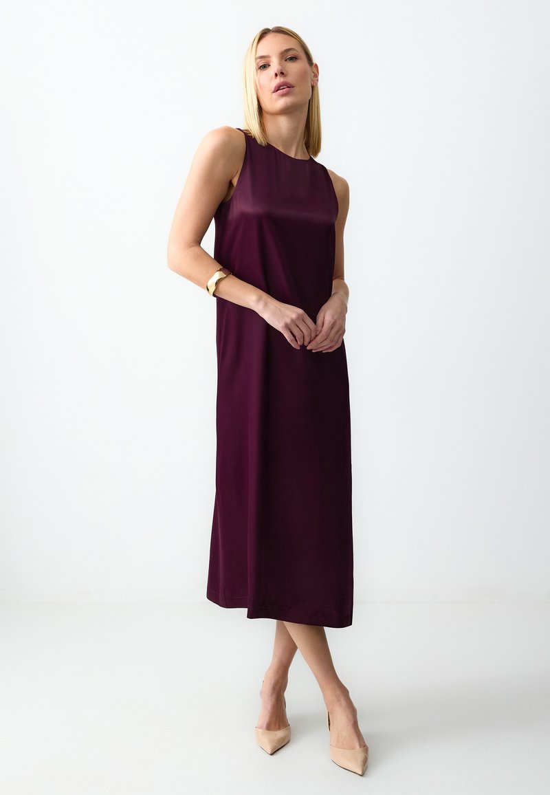 Robe sans manches bourgogne avec une silhouette droite, confectionnée en tissu lisse, présentant un ourlet au genou et un design minimaliste.