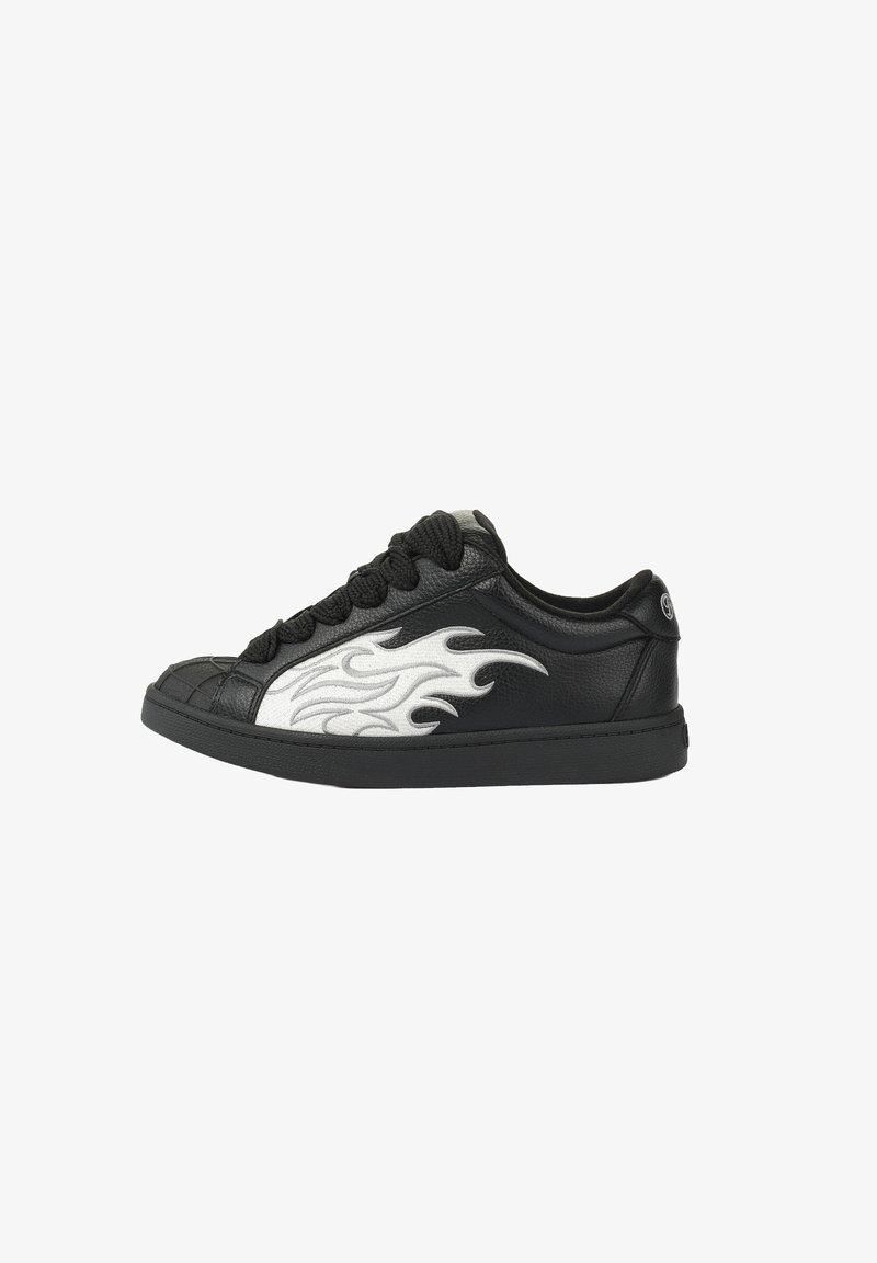 Baskets basses noires avec des lacets noirs épais et un motif de flammes blanches sur le côté, embout texturé et logo sur le col du talon.