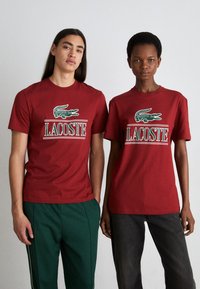 Lacoste - UNISEX - Apdrukāts T-krekls - ora Miniatūras attēls 1