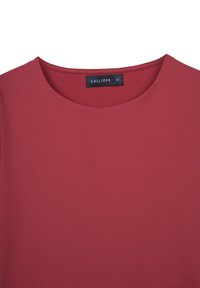 Top rosso con collo rotondo, realizzato in tessuto morbido. Presenta un'etichetta con il nome del marchio Calliope e la taglia S cucita all'interno.