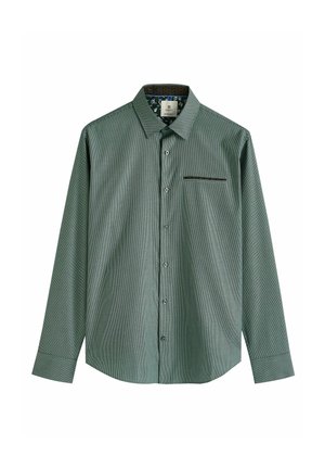 Chemise à manches longues verte à carreaux avec un col pointu, une poche frontale et une fermeture à boutons. Présente un revêtement à motif à l'intérieur du col.