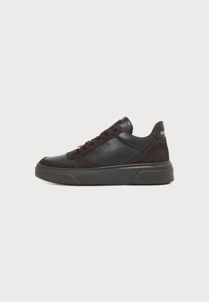 Czarny niski sneaker z panelami ze skóry i zamszu, z przodu sznurowany, z grubą gumową podeszwą, pokazany z profilu.
