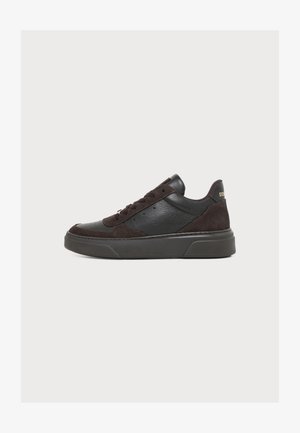 Czarny niski sneaker z panelami ze skóry i zamszu, z przodu sznurowany, z grubą gumową podeszwą, pokazany z profilu.