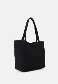 Černá látková taška na rameno s dvěma dlouhými uchy, jednoduchý obdélníkový design. Hladká textura, bez viditelných kovových částí nebo vzorů.