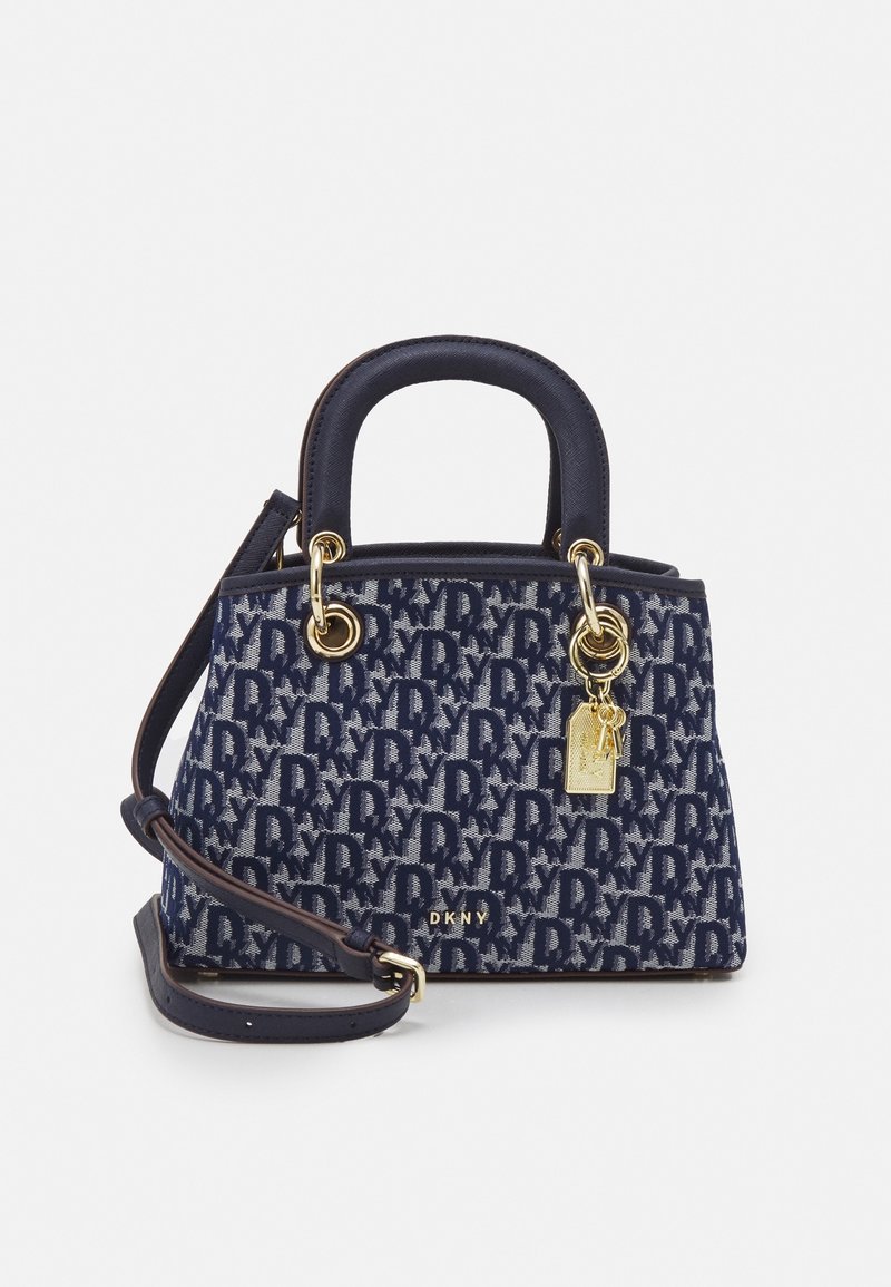Sac à main DKNY bleu marine avec motif monogramme, ferrures dorées, poignées supérieures, une bandoulière amovible et un porte-clés doré.