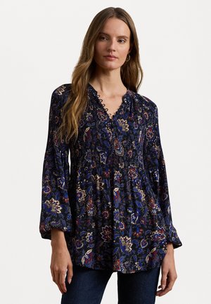 Flödande, marinblå blus med blommönster i röd, blå och guld. Har en V-ringning med volangdetaljer och stora ärmar. Mjuk tygkvalitet.