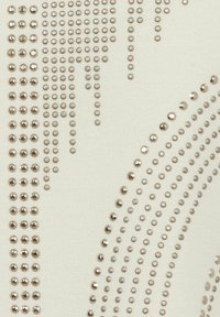 Beige-Stoff mit metallischen Pailletten, die in kreisförmigen und linearen Mustern angeordnet sind und Textur sowie visuelles Interesse erzeugen.