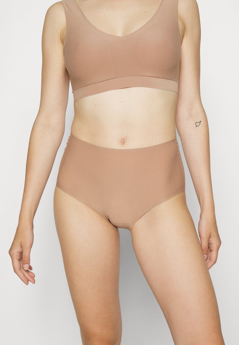 Nahtloser BH und hochgeschnittene Panties aus leichtem, dehnbarem, hellbraunem Stoff. Schlichte Gestaltung mit glatter Textur und ohne sichtbare Beschläge.