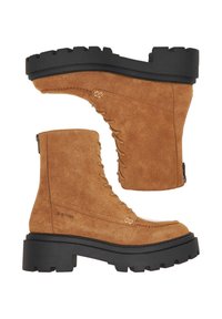 Hnedé semišové členkové čižmy s masívnou čiernou podrážkou, s dizajnom na šnurovanie a zipsom na jednej strane pre jednoduchšie obliekanie.