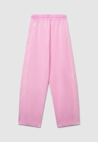 Pantalon court rose clair avec une taille élastique, doté d'une texture lisse et de coutures latérales. Design simple sans motifs supplémentaires.