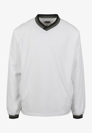 Valkoinen pullover-takki, jossa on ribattuja musta-valkoisia raitoja kauluksessa. Takissa on pitkät hihat ja sileä pinta. Sivutaskut kuuluvat varustukseen.