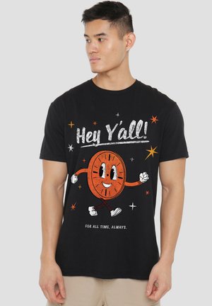 Schwarzes Baumwoll-T-Shirt mit einem Cartoon-Uhr-Charakter mit Armen und Beinen sowie dem Text "Hey Y'all!" in Weiß und Orange, umgeben von Sternen.