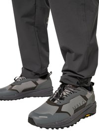 Graue und schwarze Wanderschuhe mit robusten Sohlen, getragen zu dunklen Hosen, die strapazierfähige Details und Schnürung von Outdoor-Schuhen hervorheben.