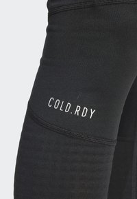 Leggings sportivi neri con un design aderente, caratterizzati dalla scritta "COLD.RDY" in bianco, una texture liscia e dettagli delle cuciture a contrasto.