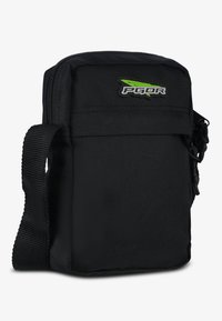 Borsa a tracolla nera in nylon con tracolla regolabile, chiusura con zip e logo verde e nero. Forma compatta e rettangolare con superficie texturizzata.