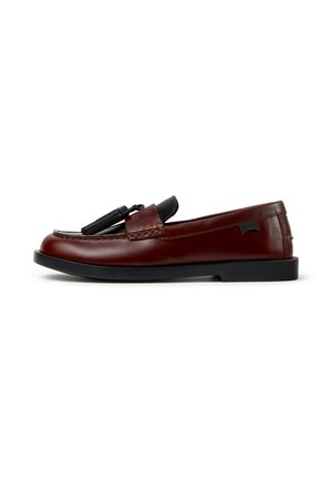 Bruine leren loafer met zwarte kwastjes, zwarte zool en merklabel aan de zijkant, in profiel tegen een witte achtergrond afgebeeld.
