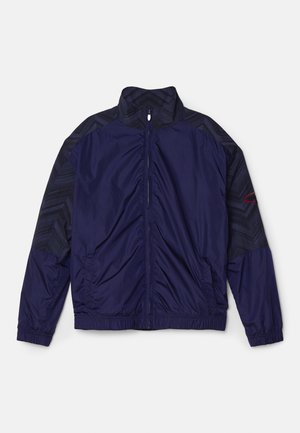 Giacca leggera blu navy con colletto alto, chiusura con zip, spalle con motivo testurizzato e polsini ed orlo elasticizzati.