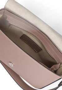 Lichtbruine leren handtas met magnetische sluiting, beige stoffen interieur en een binnenzak met rits, gelabeld "Made in Italy."