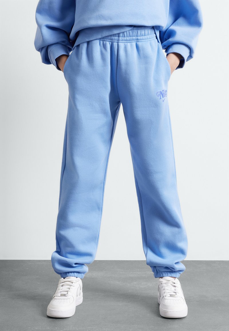 Pantalones de chándal azul claro, confeccionados en una tela suave, con una cinturilla y puños elásticos, y un sutil bordado de la marca en la parte frontal.