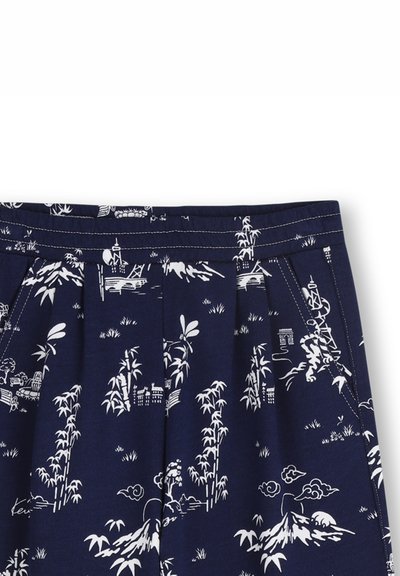 Shorts en tissu bleu marine avec motifs blancs d'inspiration asiatique représentant du bambou, des montagnes et des paysages ; design plissé avec ceinture cousue.