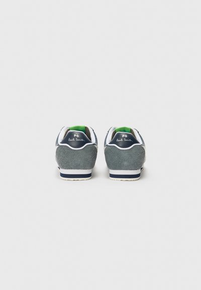 Adidași din suede bleumarin cu accente albe și un tab de călcâi verde, având un spate texturat și o talpă din cauciuc cu un model cu dungi.