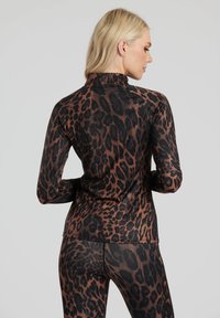 Top a maniche lunghe con stampa leopardata e collo alto, caratterizzato da una combinazione di colori marrone e nero, texture liscia e design aderente.