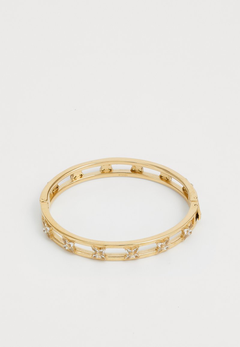 Gouden metalen bangle armband met heldere edelstenen in stervormige vormen, open ontwerp met een gladde afwerking en een veilige sluiting.