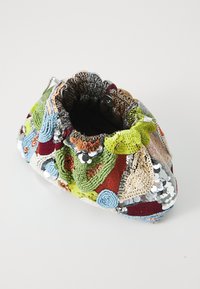 Colorful patchwork handbag featuring textured embroidery, sequins, and a drawstring closure. Diverse colors include green, blue, and red.